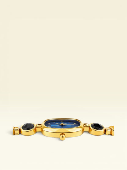 Labdhi Watches & Premium TimeGold watch with a blue dial, gold-tone case, and black stone accents on the bracelet.